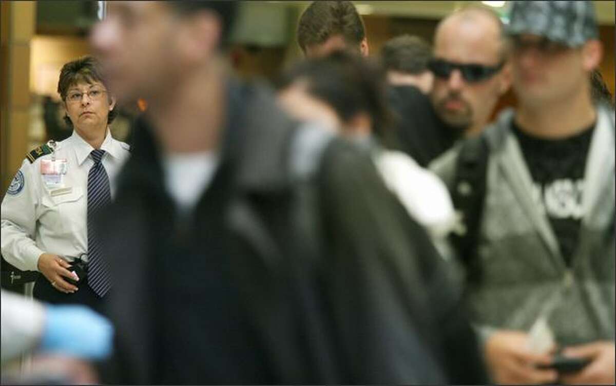 Della Winn, a TSA behavioral detection officer, watches over passengers as they approach a security checkpoint at Sea-Tac International Airport on Friday.