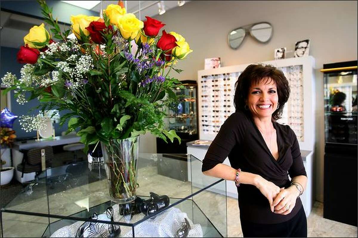Maria McLaren, wife of Mariners manager John McLaren, is all smiles in her new Glendale, Ariz., store, Eye Styles Optical. She is surrounded by flowers bought by her husband.