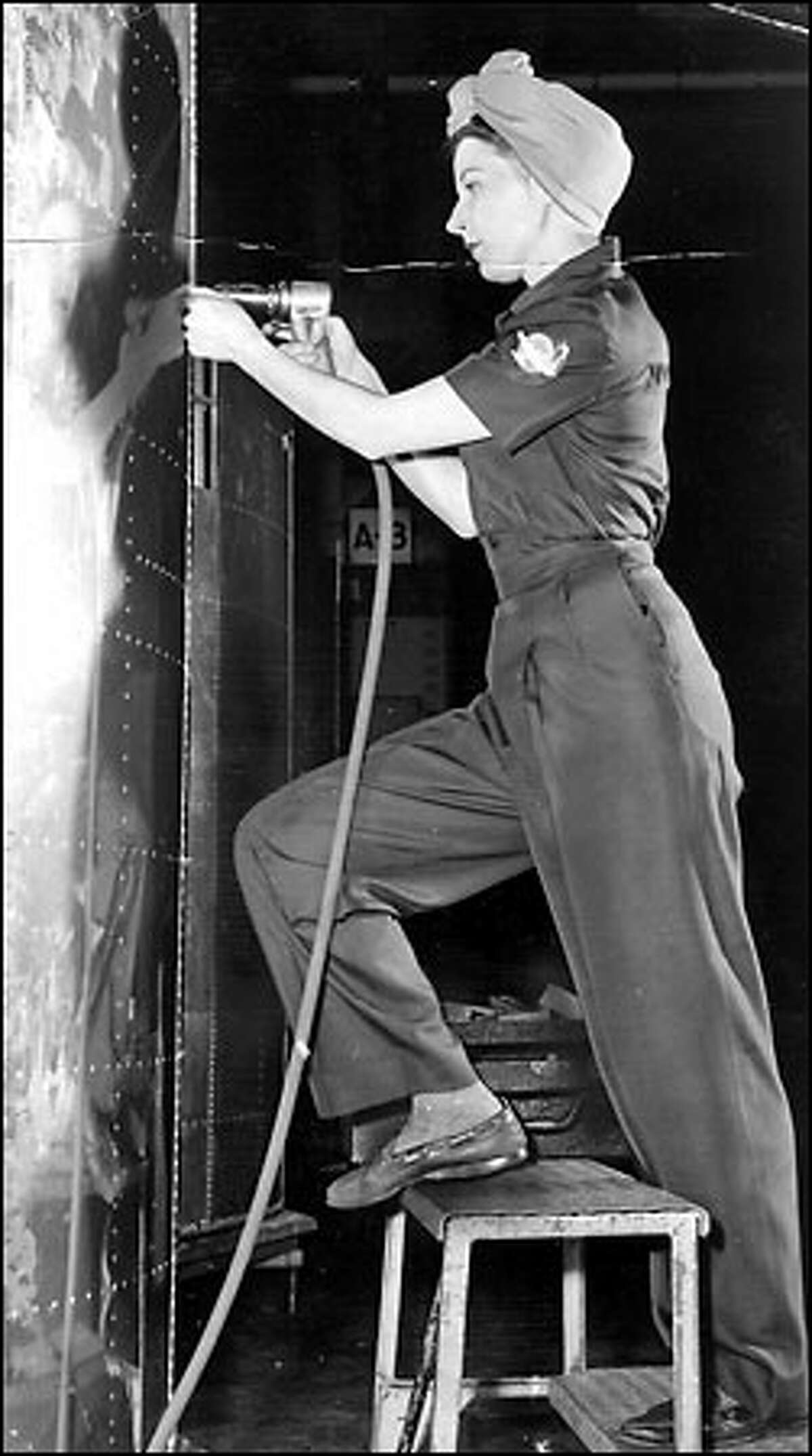 Rosie the Riveter, 1943: Elaine Tosch does her riveting clad in a fashionable Flying Fortress uniform by Miss King. Thousands of women joined the Boeing production line during World War II as airplane output shifted into high gear.