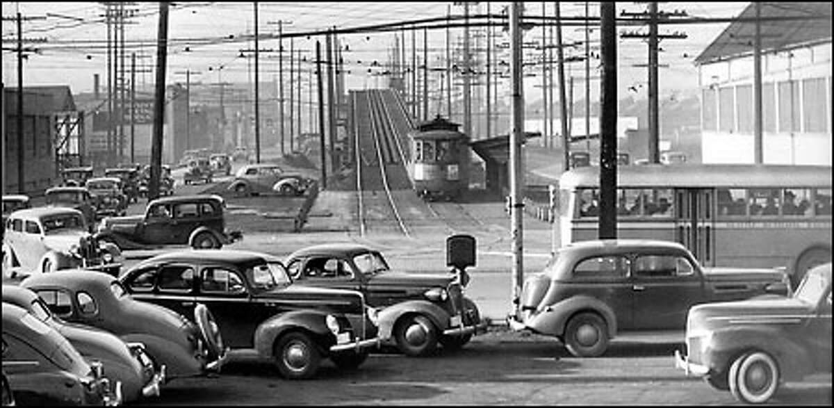 Traffic congestion, 1940: On a normal day of traffic in Seattle, trolleys, buses and cars converge in the industrial area at the intersection of Fourth Avenue South and South Spokane Street. By 1944, the Spokane Street Viaduct was completed, and it diverted some of the regular traffic, making Fourth an easier route into downtown.