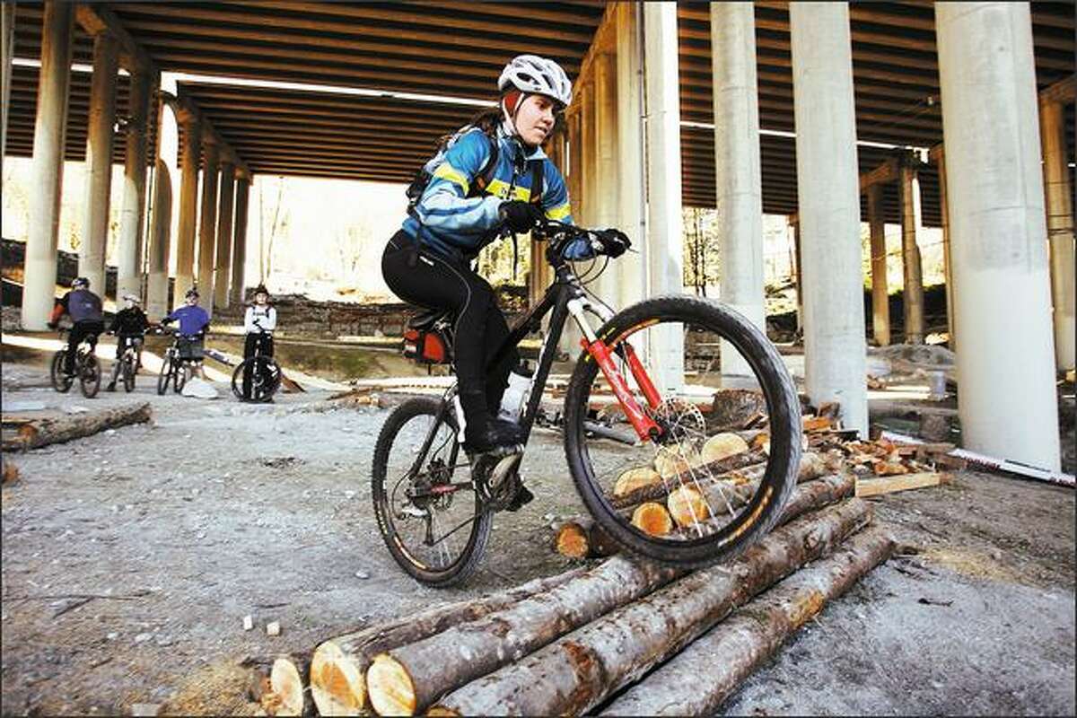 Lori Williams sharpens her riding ability with a "skills session" with a group from the Backcountry Bicycle Trails Club in a class at Colonnade Park under I-5.