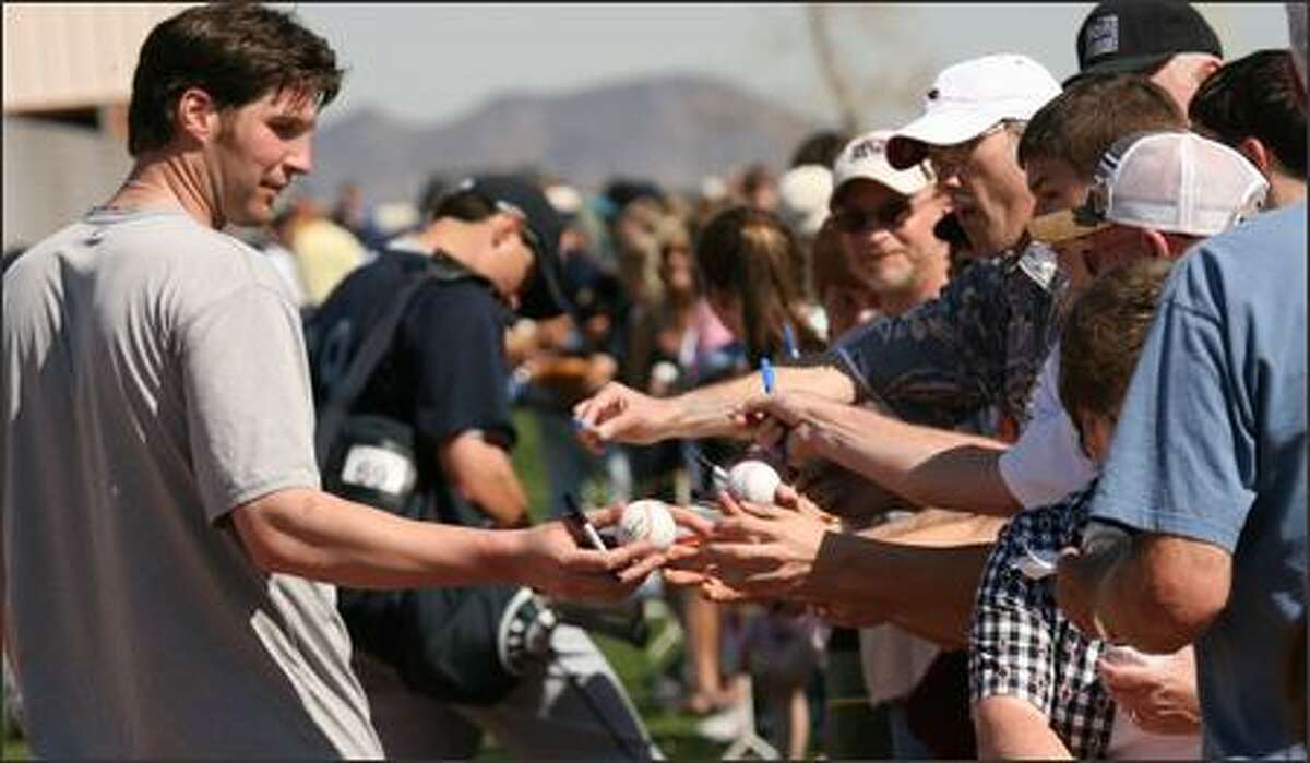 Richie Sexson hands an autographed ball back to a fan after Wednesday's workout.