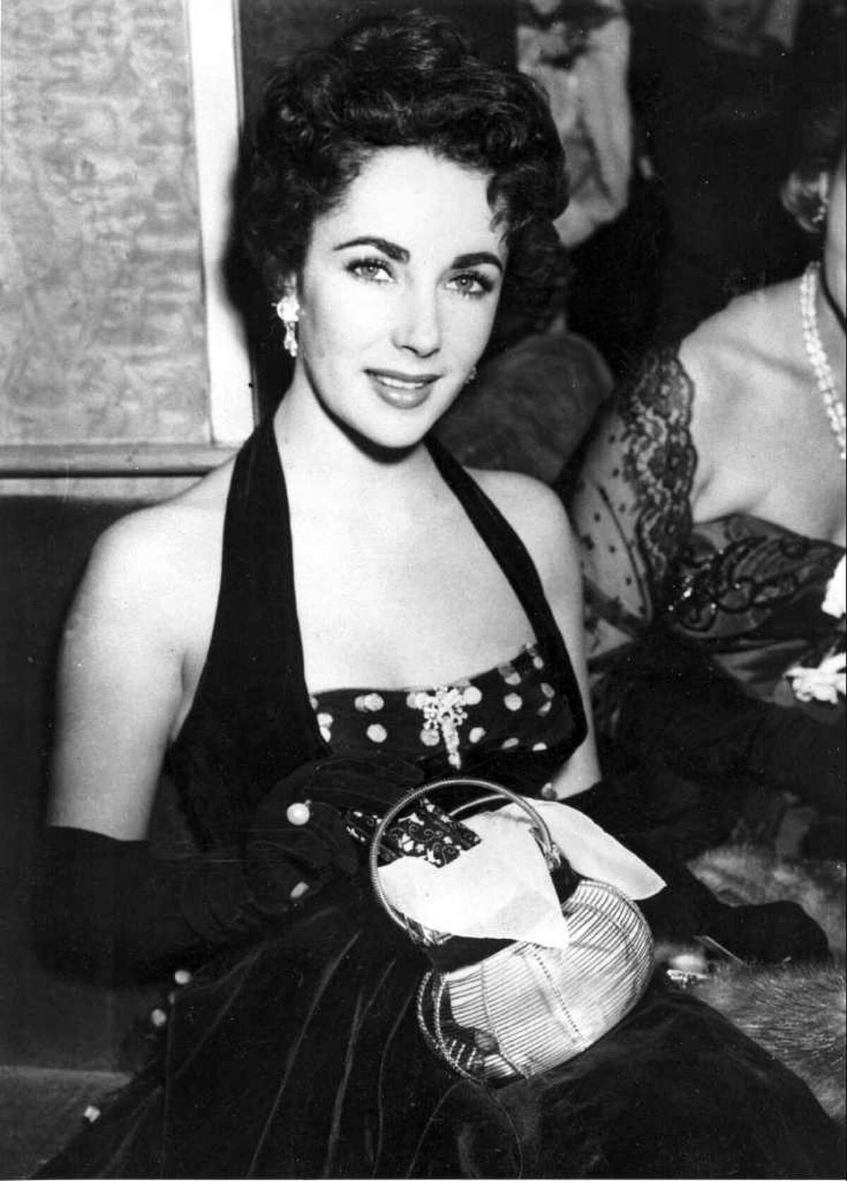 American actress Elizabeth Taylor is shown at the premiere of "The Lady with the Lamp" at the Warner Theater in London, England, Sept. 22, 1951. (AP Photo)