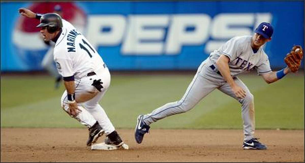 Edgar Martinez takes second base on a Bret Boone single as Texas' Michael Young misses the tag in the fourth inning. Boone's looped single to right scored Jolbert Cabrera.