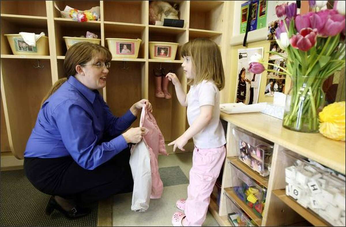 Cecilia Phillips, 3, shows her mom, Lorraine Lewis Phillips, a tulip Friday at Bright Horizons child care center. Phillips was picking up her children after a day at the office. The attorney works at Keller Rohrback in Seattle.