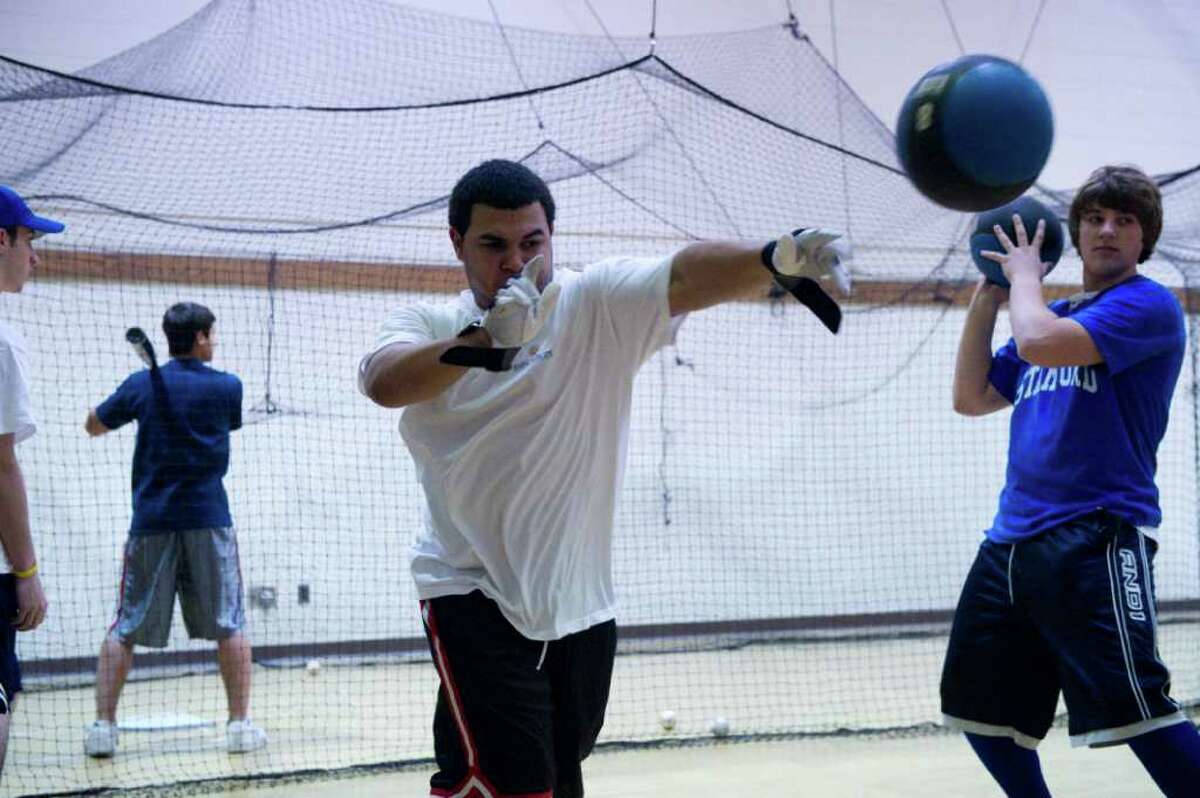 The Westhill High School baseball players Rangel Polonia, left, and Andrew Denkus practice in the school's gym in Stamford, Conn., March 23, 2011. The team will not be able play on their home field this season because dugouts are not ready for season.