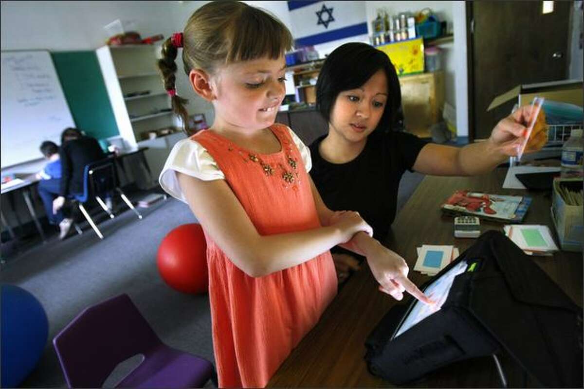 Morgan Brewer, 8, works with Lovelle Suarez to answer a matching problem at the Academy for Precision Learning, which uses individual programs for its students.
