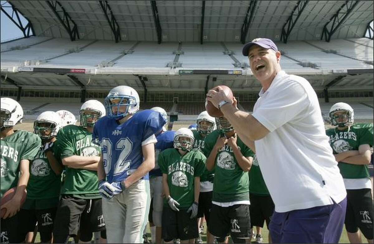 Ed Donatell, Washington's first-year defensive coordinator, works with players during one of the Huskies' three football camps in June.