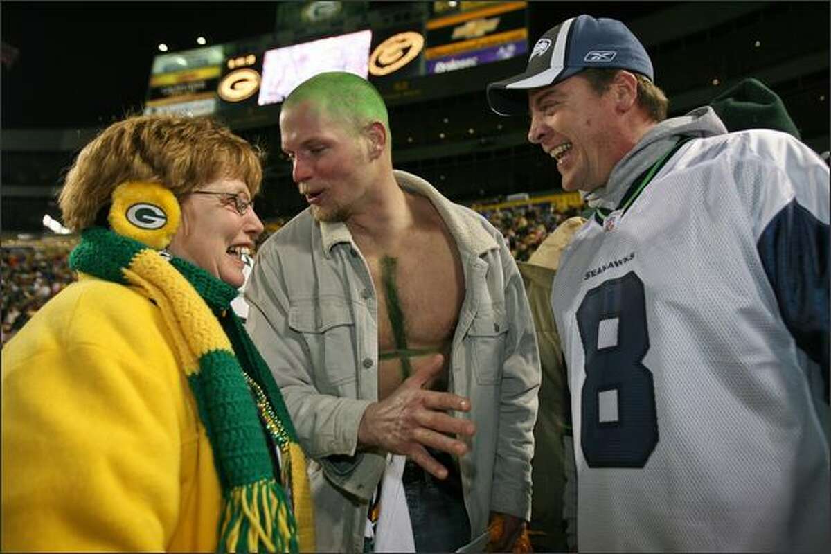 Deborah Schnider, from Winthrop Harbor, Illinois, and Ray Howll, wearing a painted #4 on his chest, from Burlington, Wisconsin, reserve comment on Glen Kanenwisher's jersey choice during a Packer pep rally held at Lambeau Field in Green Bay, Wisconsin. Kanenwisher is a Boeing manager from Seattle who is celebrating his 46th birthday at Lambeau Field.