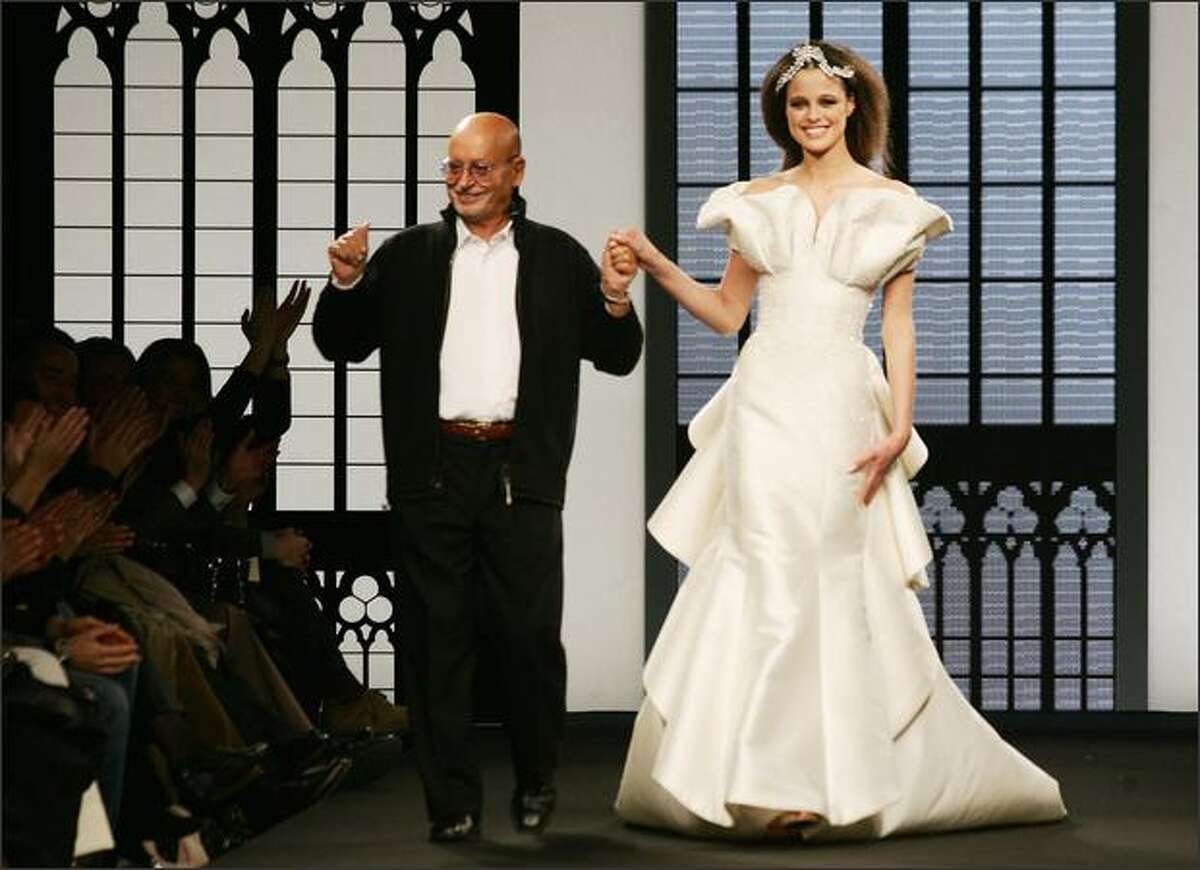 Italian designer Fausto Sarli (L) strides down the catwalk at the end of his Spring/Summer 2008 Haute Couture collection show in Rome's Auditorium Hall during Rome's Fashion Week, Sunday.