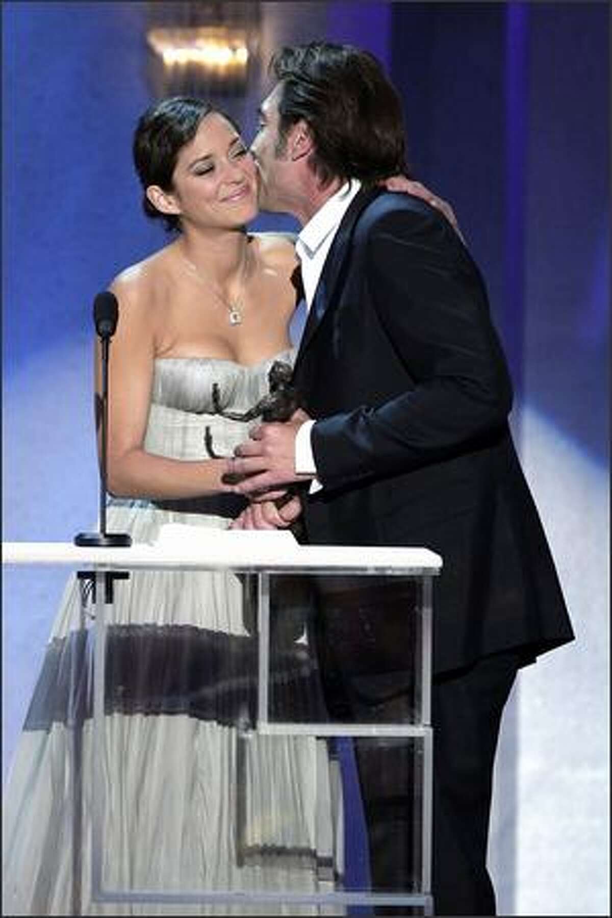 Javier Bardem, right, kisses presenter Marion Cotillard as he accepts the award for outstanding performance by a male actor in a supporting role for "No Country For Old Men" during the 14th annual Screen Actors Guild Awards.