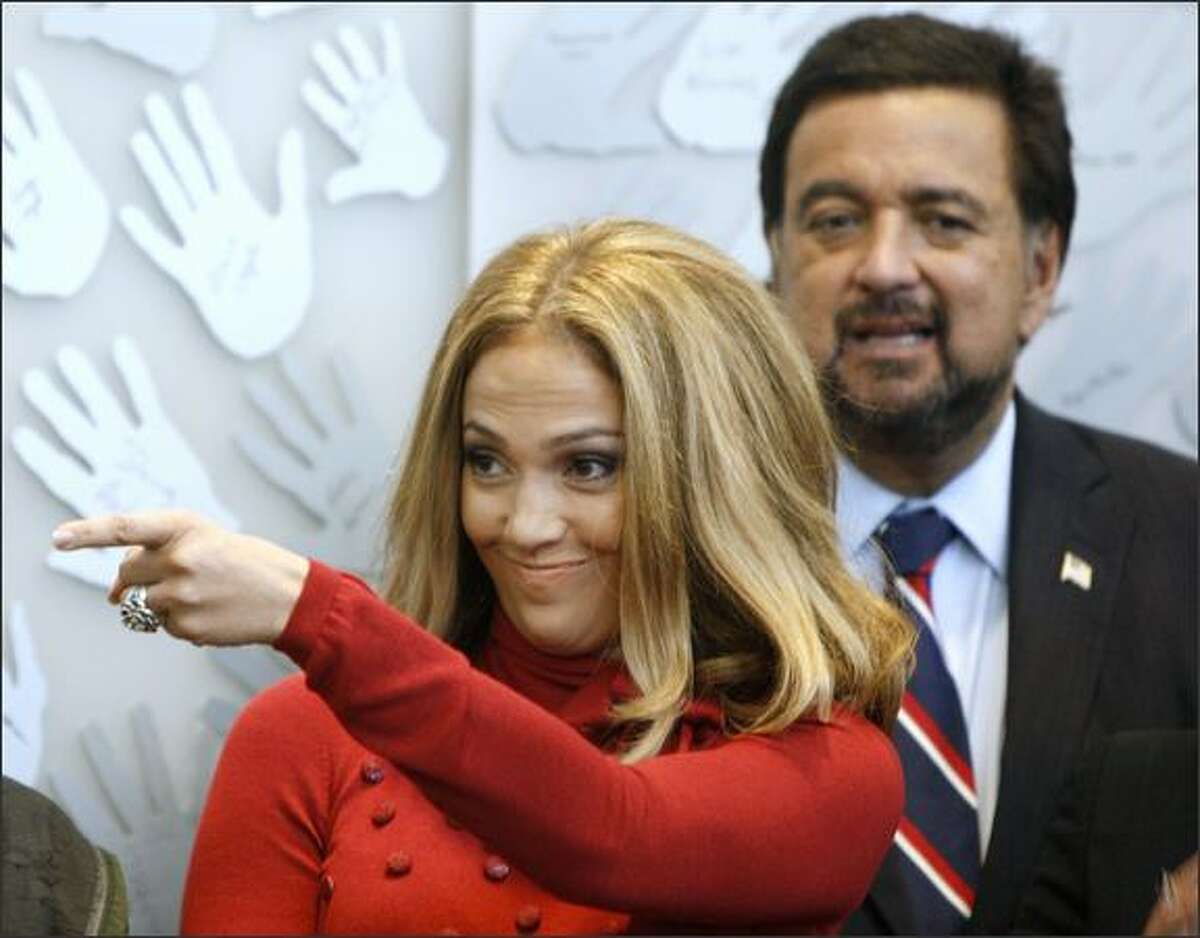Jennifer Lopez, standing in front of New Mexico Gov. Bill Richardson, spoke at a reception in Denver honoring children’s rights activist Marian Wright Edelman.