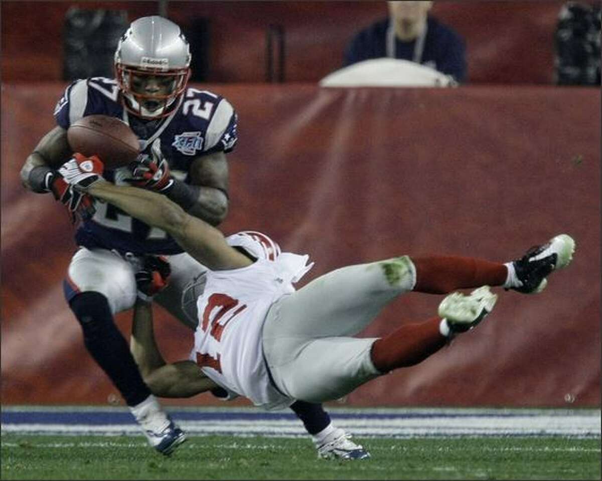 New England Patriots cornerback Ellis Hobbs III, left, intercepts a pass intended for New York Giants receiver Steve Smith in the second quarter of Super Bowl XLII.