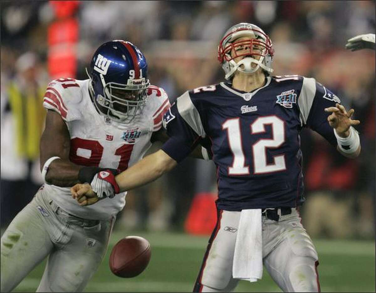 New York Giants defensive end Justin Tuck strips the football from New England Patriots quarterback Tom Brady during the second quarter of Super Bowl XLII.