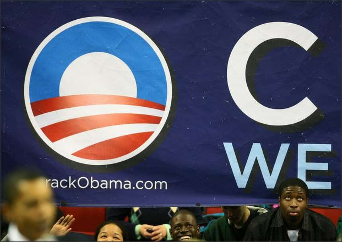 A suupporter of democratic presidential candidate Sen. Barack Obama peeks from behind a banner during a rally at Key Areana in Seattle.