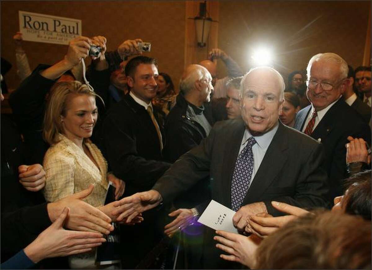 Republican presidential candidate Sen. John McCain makes his way through a receiving line as he arrives to address supporters at the Westin Hotel in Seattle. But not all were supporters as evidenced by the Ron Paul sign.