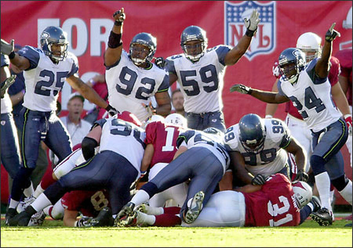 Reggie Tongue (25), Lamar King (92), Tim Terry (59) and Shawn Springs (24) indicate Seattle's possession after the Cardinals' Marcel Shipp (31) fumbled the ball during the third quarter.
