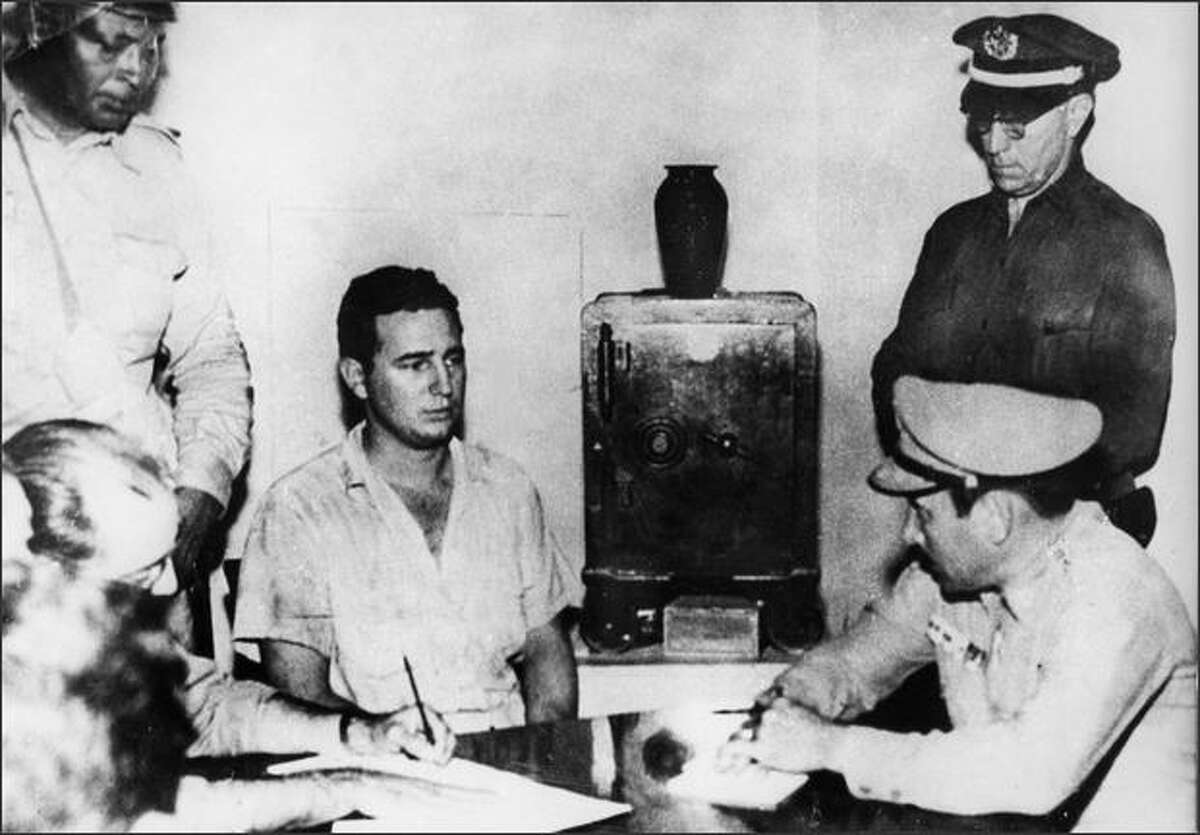 Fidel Castro, second from left, under arrest, after the July 1953 Moncada Barracks Attack. In this photo, he gives a deposition to Col. Alberto Del Río Chaviano, military chief of the Moncada Garrison, Maj. Jose Izquierdo, chief of police, and members of the Regimental Intelligence Service of Santiago de Cuba, at the Vivac in Santiago de Cuba, July 1953. AFP/Getty Images
