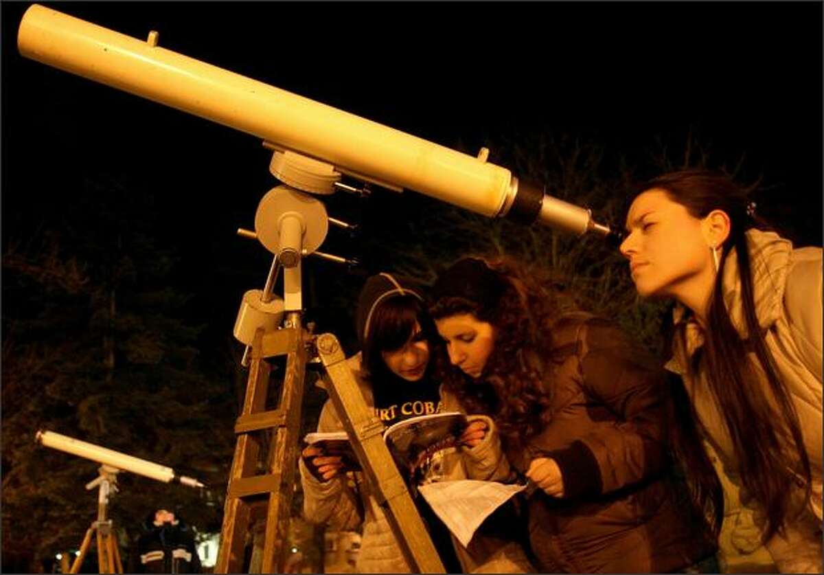 Amateur astronomers look at a partially eclipsed moon in the town of Varna, east of the Bulgarian capital Sofia. The last total lunar eclipse until 2010 occurred Wednesday night, with cameo appearances by Saturn and the bright star Regulus on either side of the veiled full moon. AP Photo/Petko Momchilov