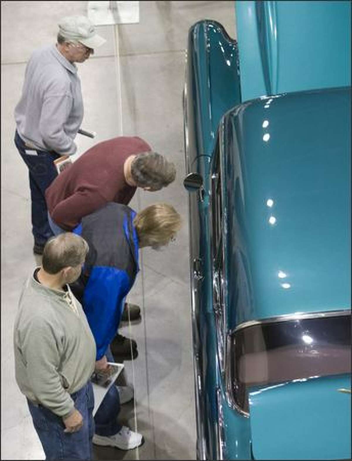 Visitors look at 1957 Chevy Bel Air Sedan owned by Ken and Angie Thomas The Seattle Roadster Show brought 283 cars, motorcycles and trucks to Qwest Field Event Center for a show of color, design, and shinny chrome for what looks like will be a gray rainy weekend.