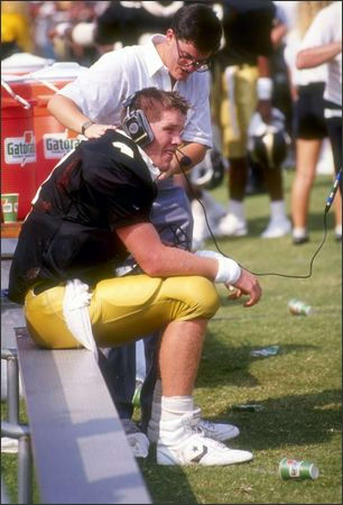 Quarterback Brett Favre, of the Southern Mississippi Golden Eagles, talks to coaches in the press box while sitting on the bench during the Golden Eagles 30-26 victory over the Florida State Seminoles at Roberts Stadium in Hattiesburg, Mississi, Sept. 2, 1989.