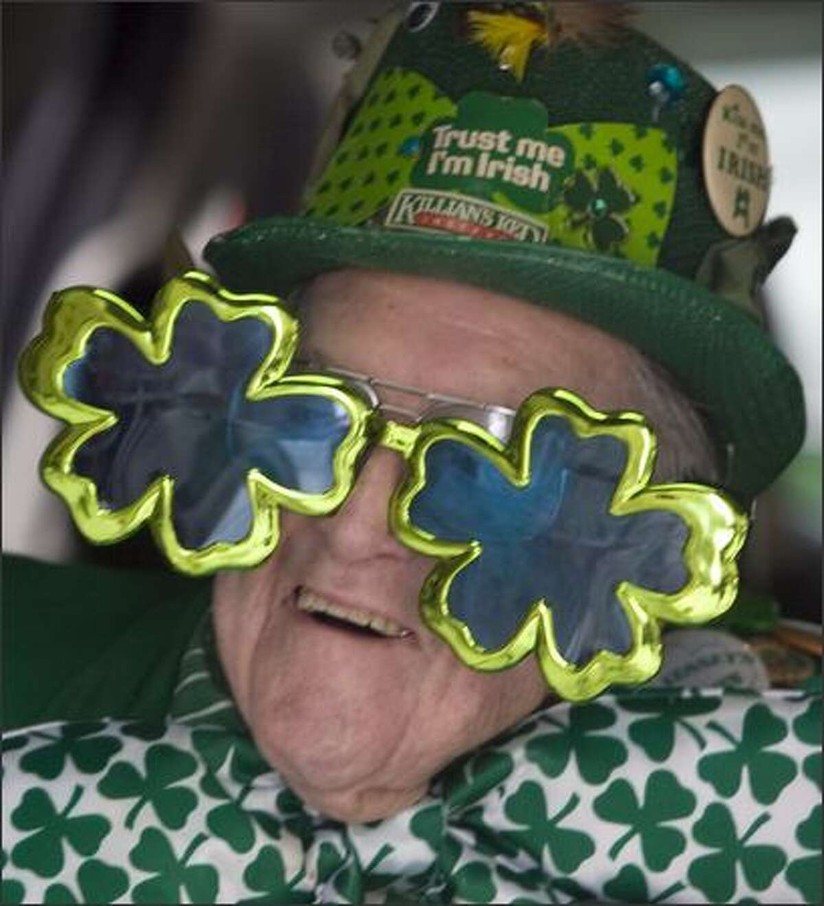 Harvey Losh, 90, enjoys the 37th annual St. Patrick's Day Parade while riding in the back of an SUV in Seattle.