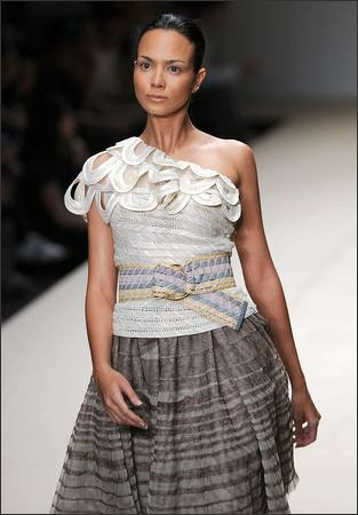A model walks the runway wearing outfits of Kai by Thai designer Somchai Kawtong.
