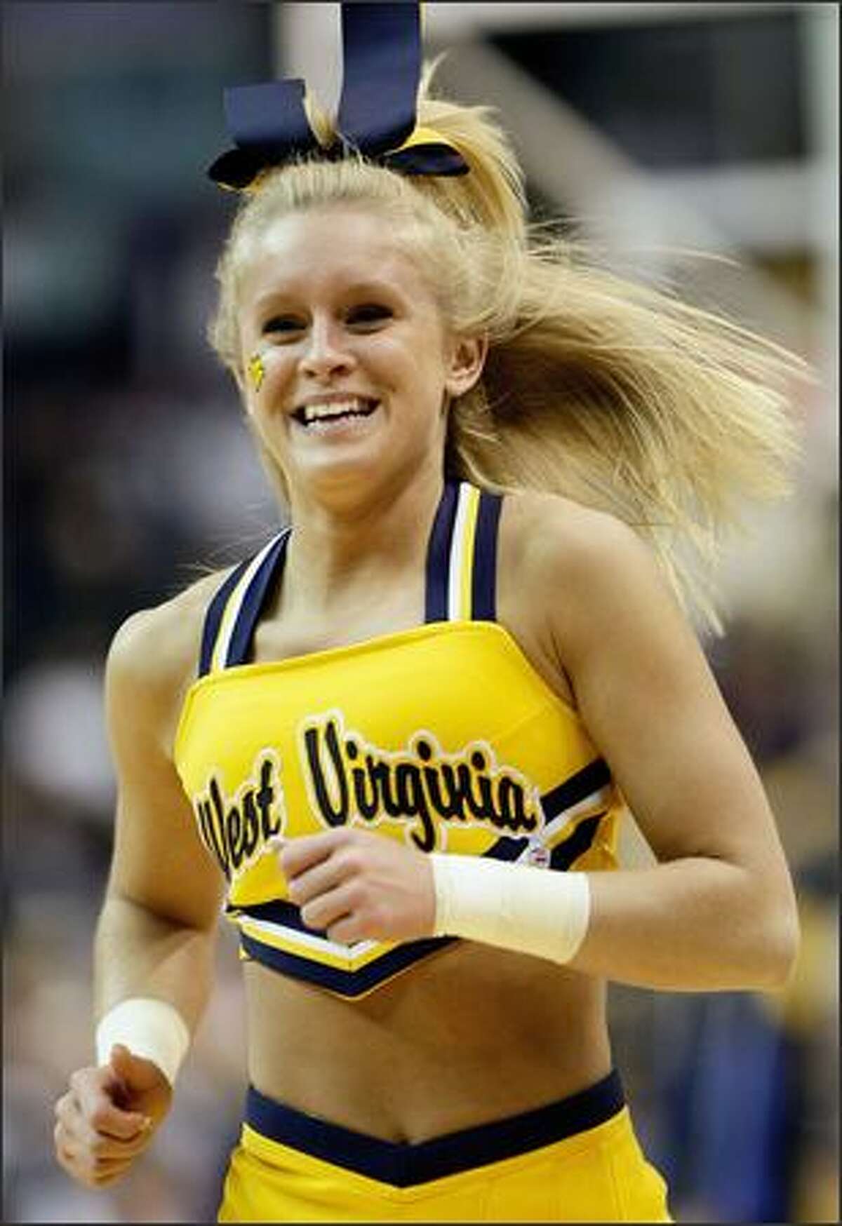 A cheerleader for the West Virginia Mountaineers preforms during a break in play against the Duke Blue Devils during the second round of the West Regional at the Verizon Center in Washington.