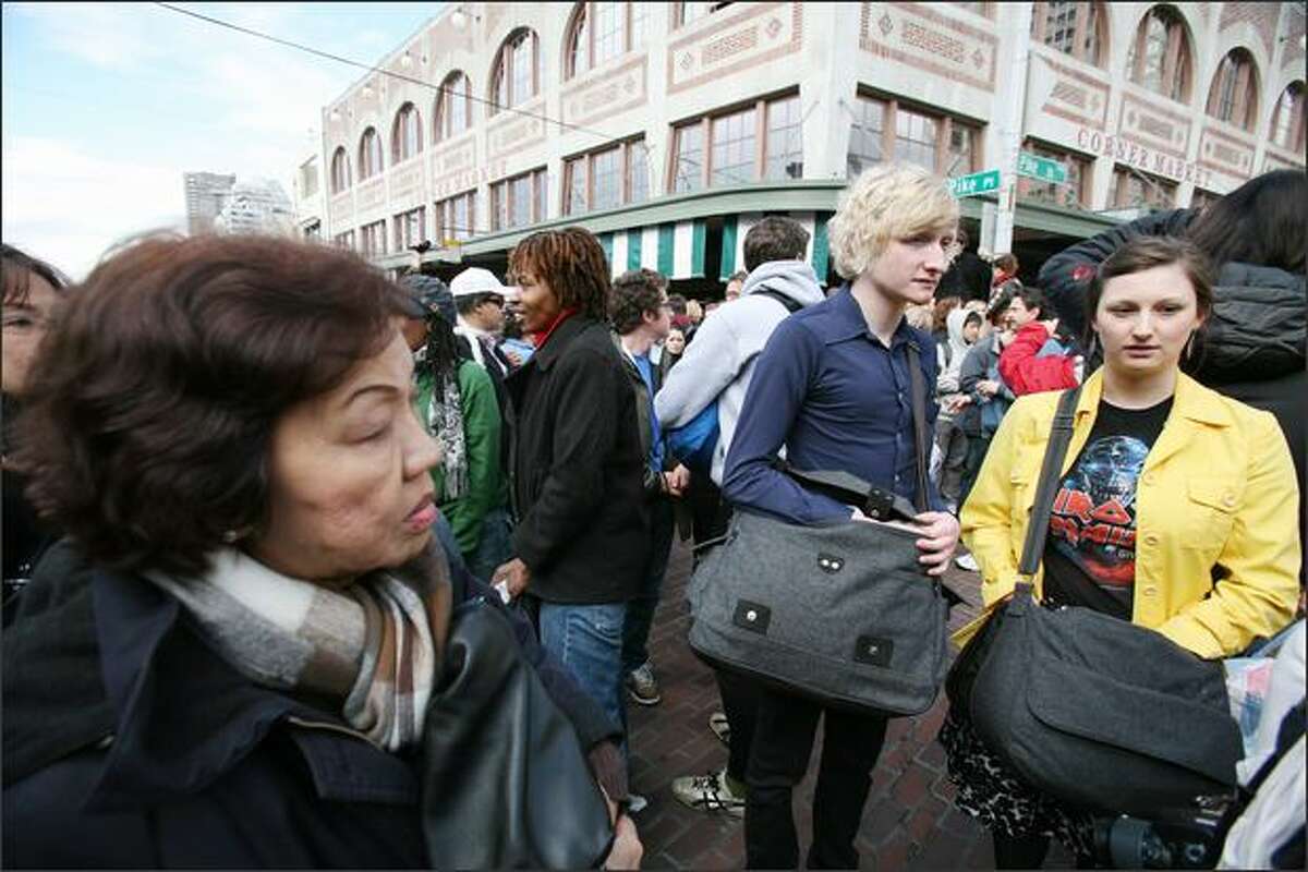 Moments before a flash mob pillow fight began at Pike Place Market on Saturday, people began reaching into their bags for their pillows.
