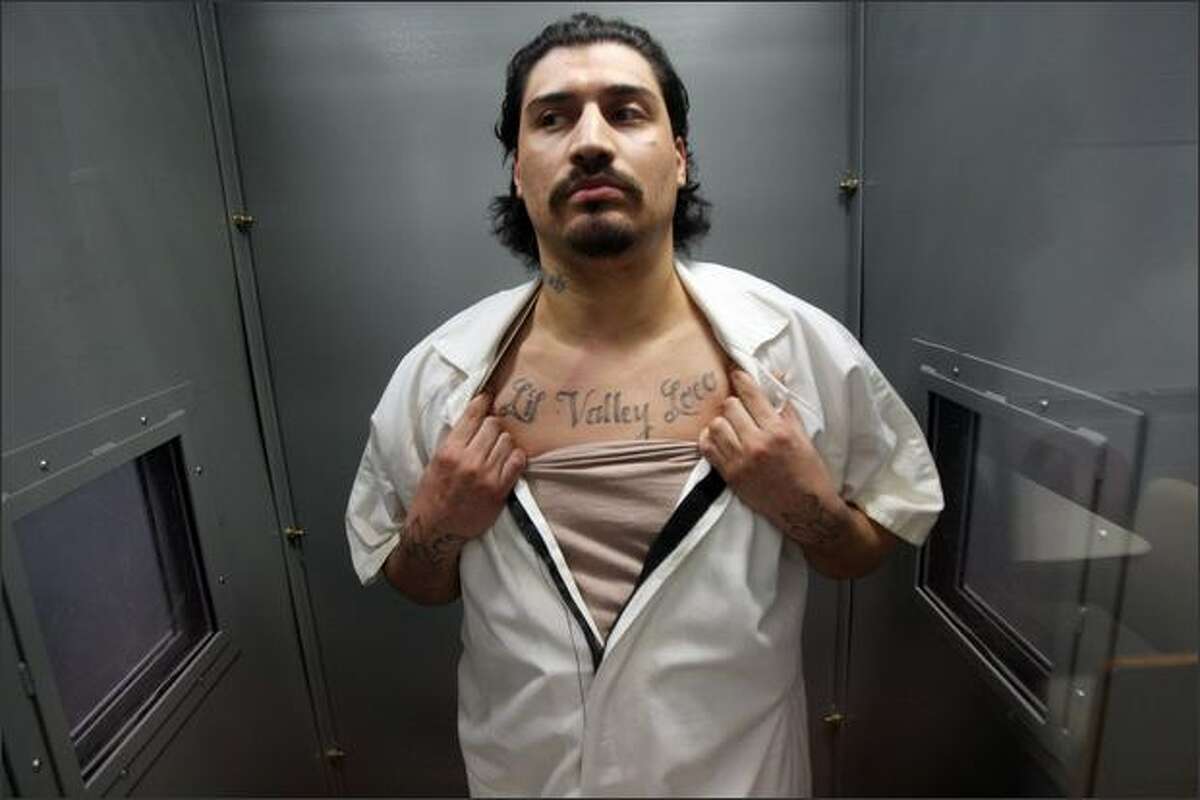 Inmate Jose Fajardo, 27, shows his tattoos while standing in the Intensive Management Unit, also known as "the hole," at Clallam Bay Corrections Center.