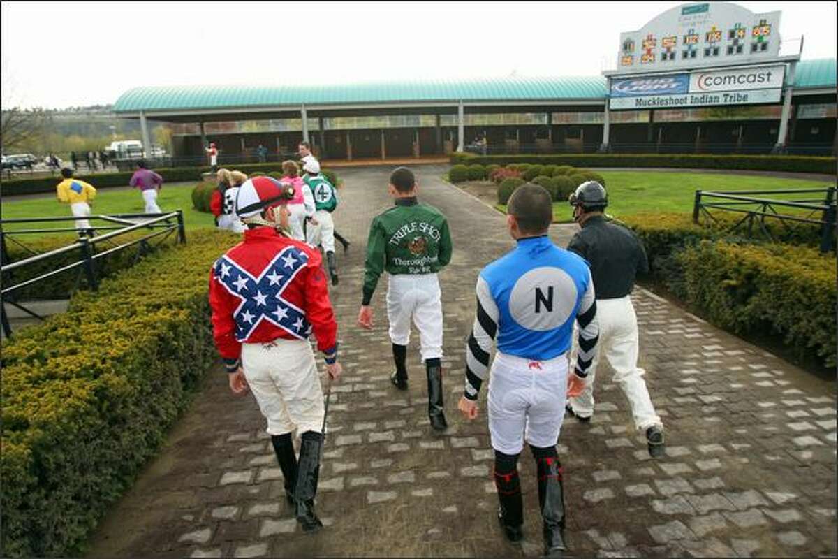 Horse jockeys head back to their locker room after being announced before the start of the first race at Emerald Downs.