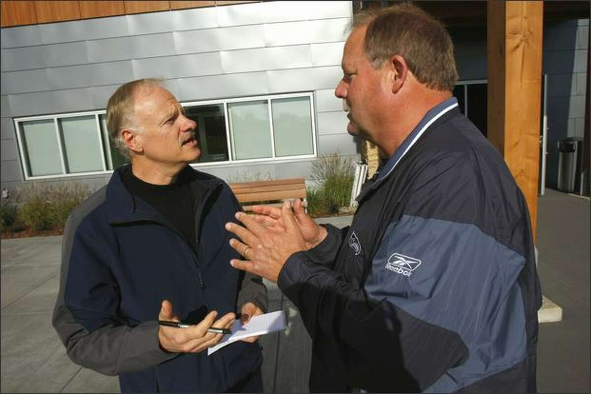 Dave Boling, left, sports columnist for the Tacoma News-Tribune, interviews Seahawks coach Mike Holmgren after a recent practice. Holmgren liked Boling’s historical novel so much he passed it along to his wife and daughters.