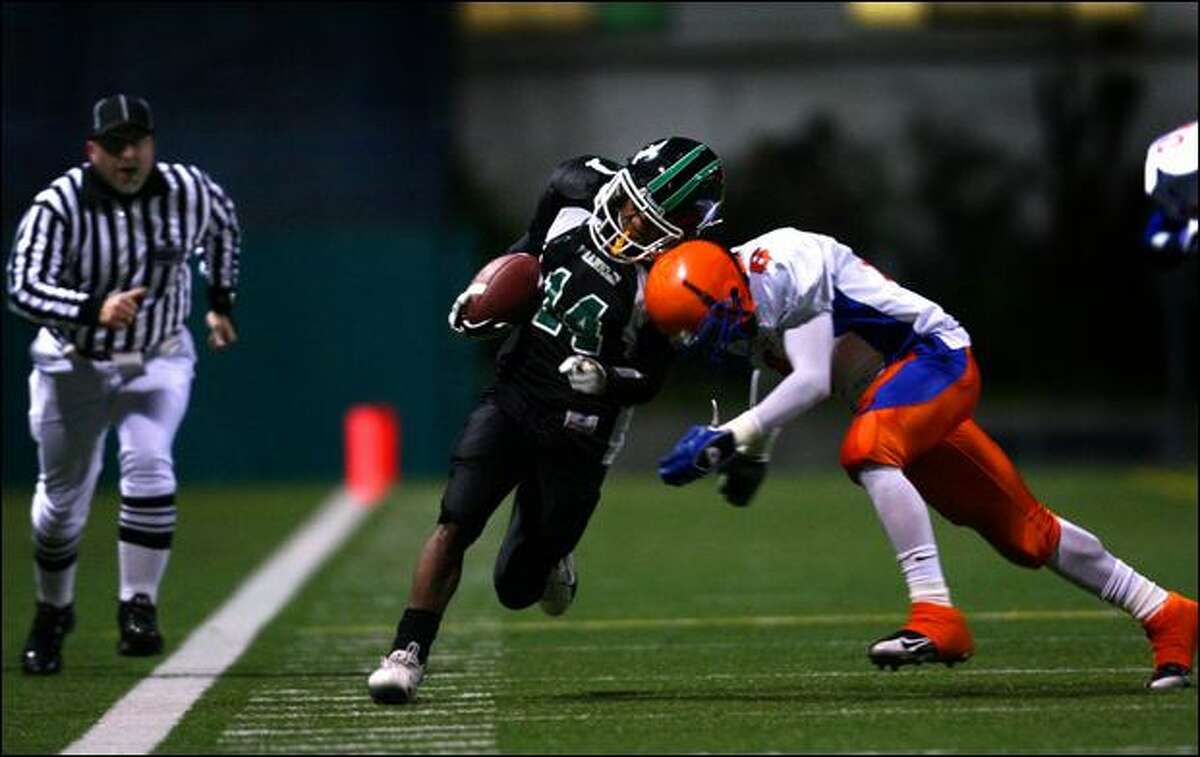 Franklin’s Leon Nelson is knocked out of bounds by Rainier Beach’s Thomas Williams in the second quarter Thursday at Memorial Stadium.