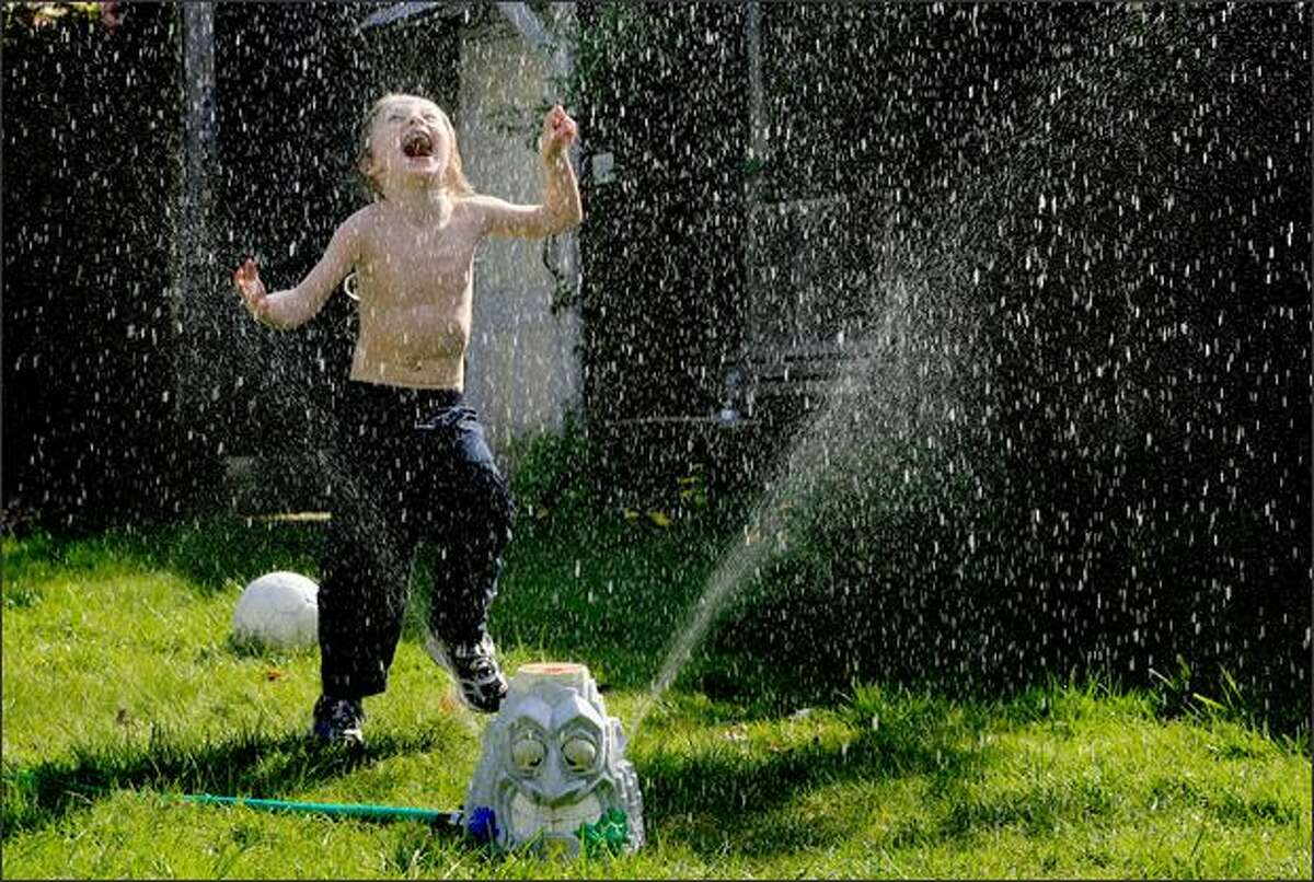 Sharky Munat, who is autistic, plays in a sprinkler outside his Capitol Hill apartment in Seattle last April. Sharky loves to play in water.