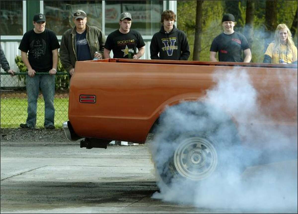 Puyallup High School students (l-r) Aaron McGraw, Colby Caine, Mitchell Shannon, Andrew Rouse, Damon Nash, and Brittan McGlauthlin watch as a driver smokes up his tires at the 2008 Green River Community College High School Drags.