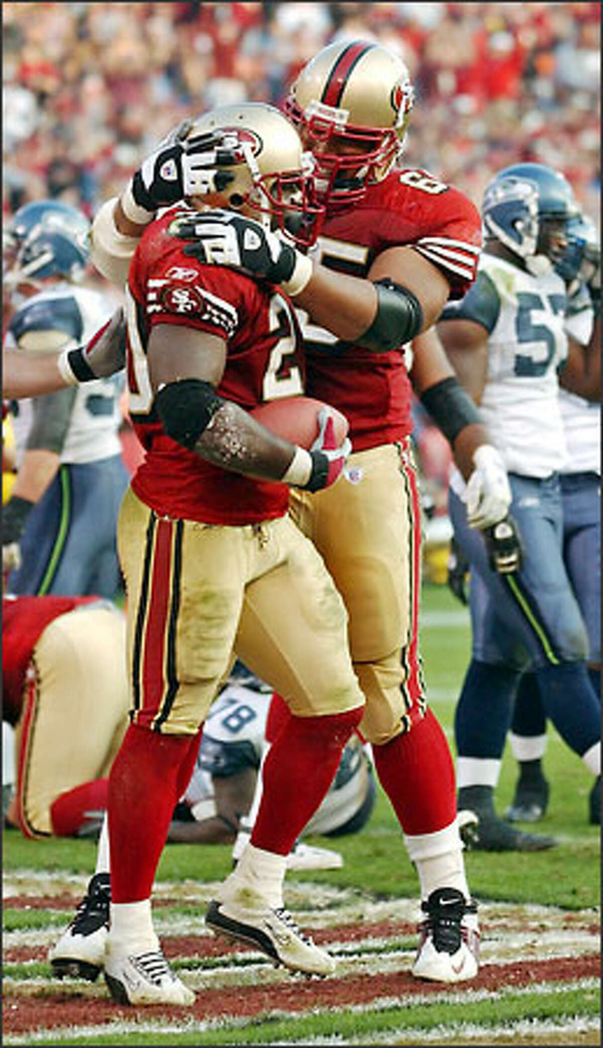 49ers running back Garrison Hearst is congratulated by guard Ron Stone after scoring in the fourth quarter, the third of his career-high three touchdowns.