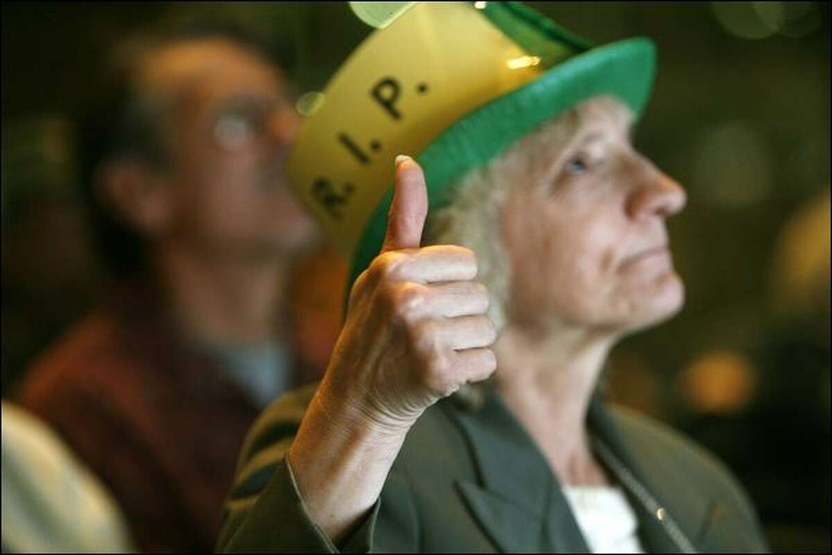 Louise Hohbach, of Seattle, gives a tributary thumbs-up for slain Edward McMichael, aka Tuba Man, during a memorial service Wednesday.