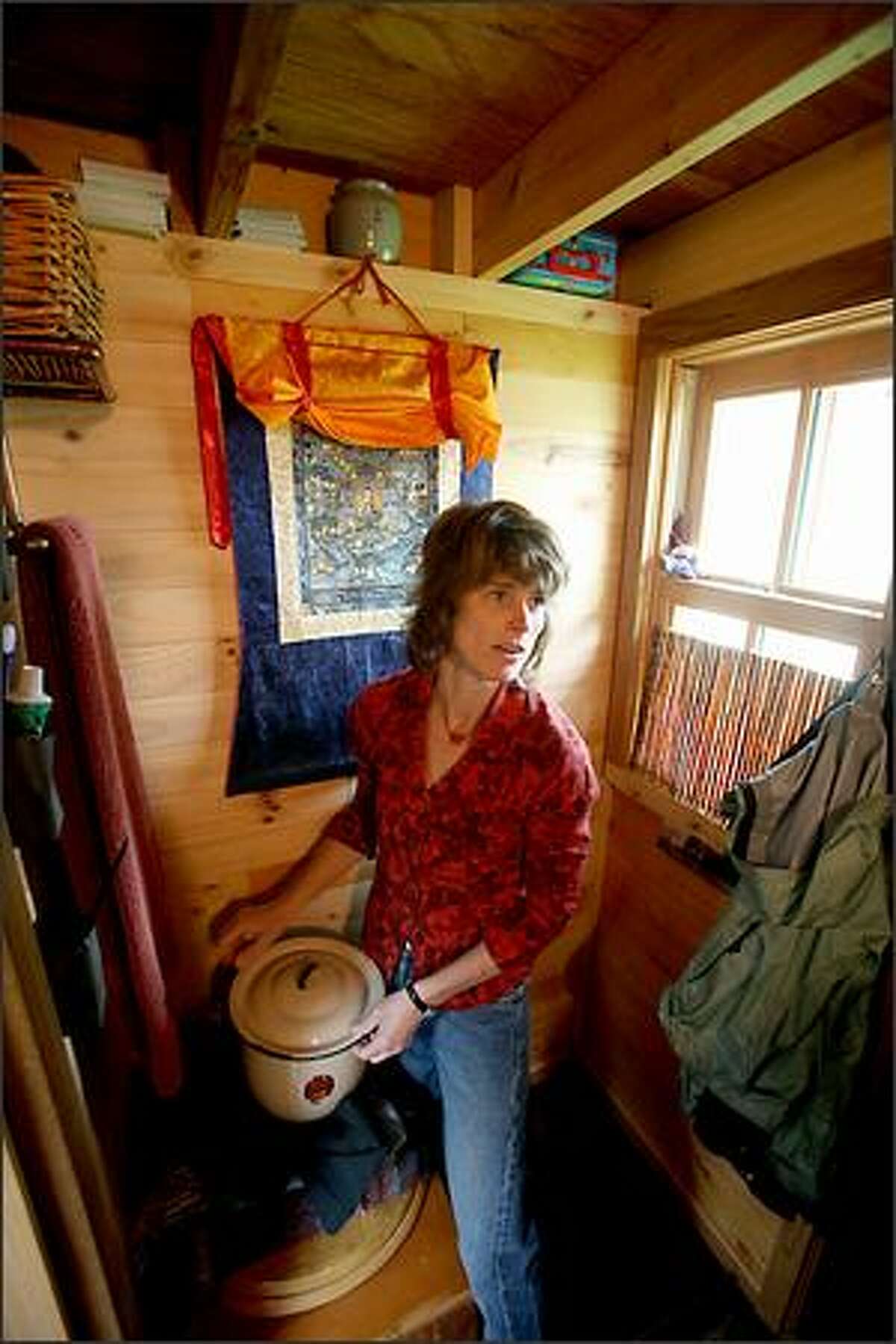 Dee Williams in the bathroom area of her 84-square-foot wooden Tumbleweed house on wheels.