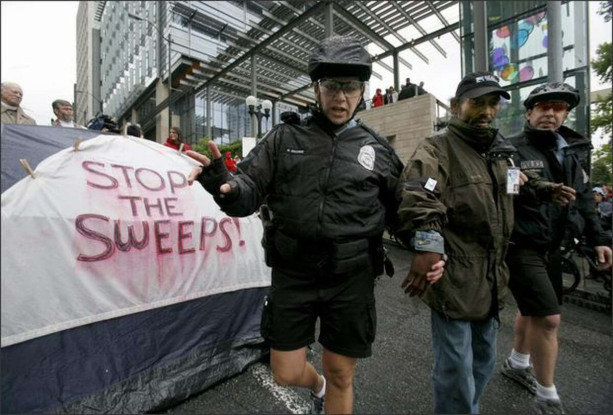 Seattle police officers arrest Calvin Turner for disrupting traffic during a protest by homeless people and advocates at Seattle City Hall.