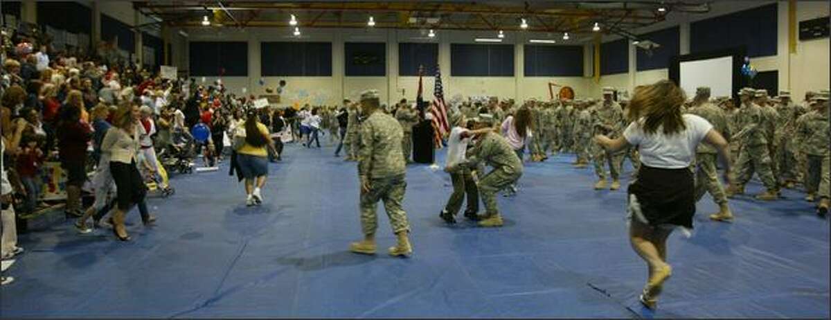 Family members and soldiers breakout of formation rush to each other after a 15-month deployment to Iraq.