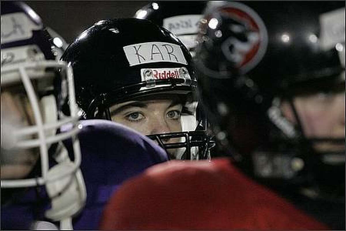 Wide receiver Karlene Clapp listens to coach Mike Talley at the beginning of practice at Kent Meridian High School.