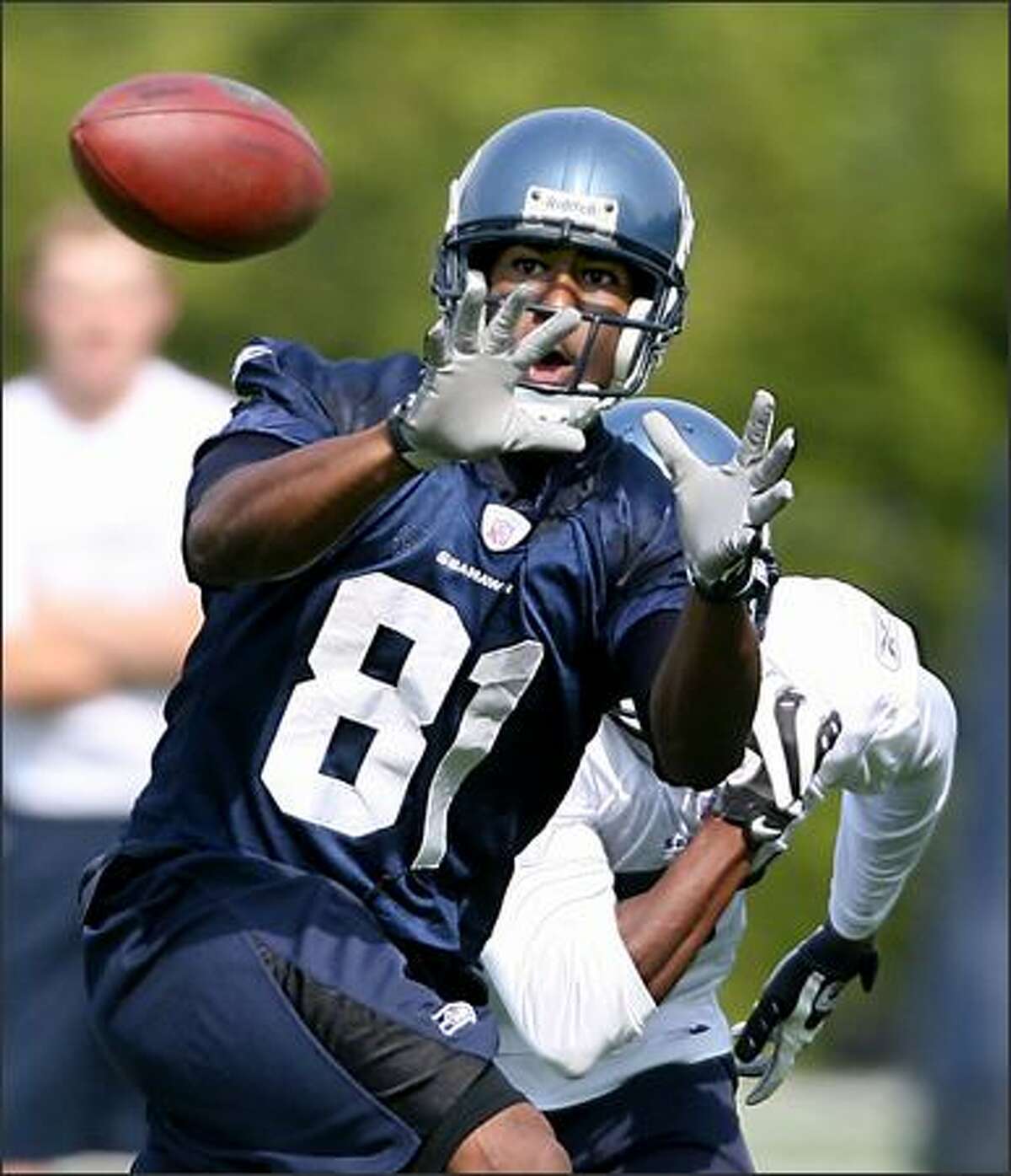 Wide Receiver Nate Burleson hauls in a pass in front of cornerback Kelly Jennings as the Seattle Seahawks hold the first practice of their 2008 season training camp at their Kirkland, Wash., headquarters Friday.