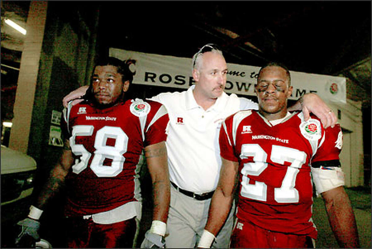 Cougars defensive line coach Robb Akey consoles middle linebacker Mawuli Davis and defensive back Eric Coleman in the tunnel leading out of the Rose Bowl. Washington State's highly regarded defense surrendered 386 yards in the 34-14 loss to Oklahoma.