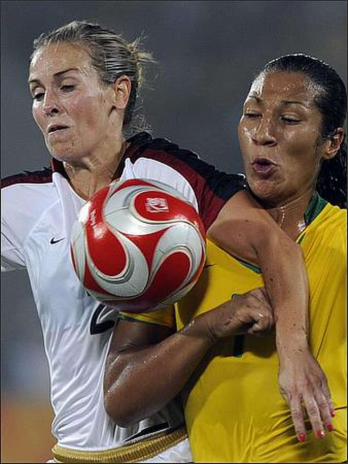 Daniela (R) of Brazil vies for the ball with Heather Mitts of US during the women's gold medal football match in the 2008 Beijing Olympic Games in Beijing.