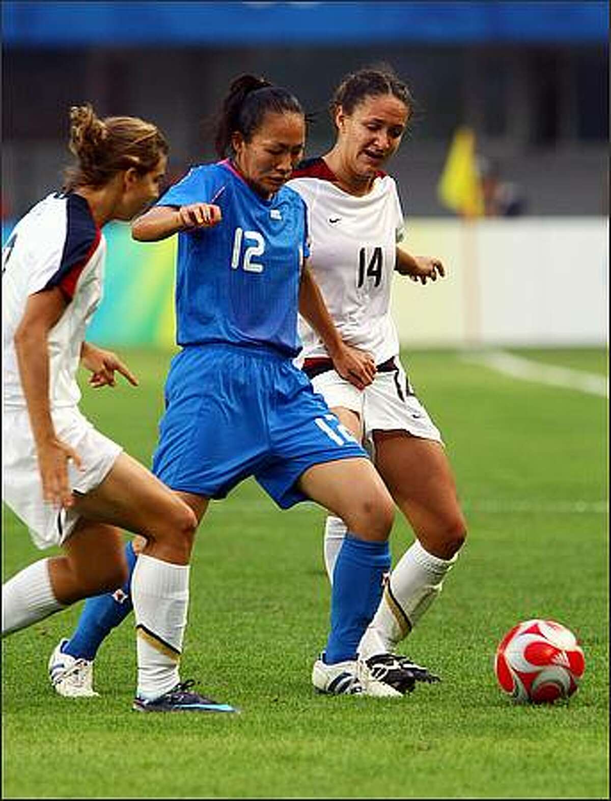 Karina Maruyama (C) of Japan vies with Stephanie Cox (R) of the US during their first round Group G women's football match of the 2008 Beijing Olympic Games at the Qinghuangdao Olympic Stadium. The defending US team defeated Japan by 1-0.