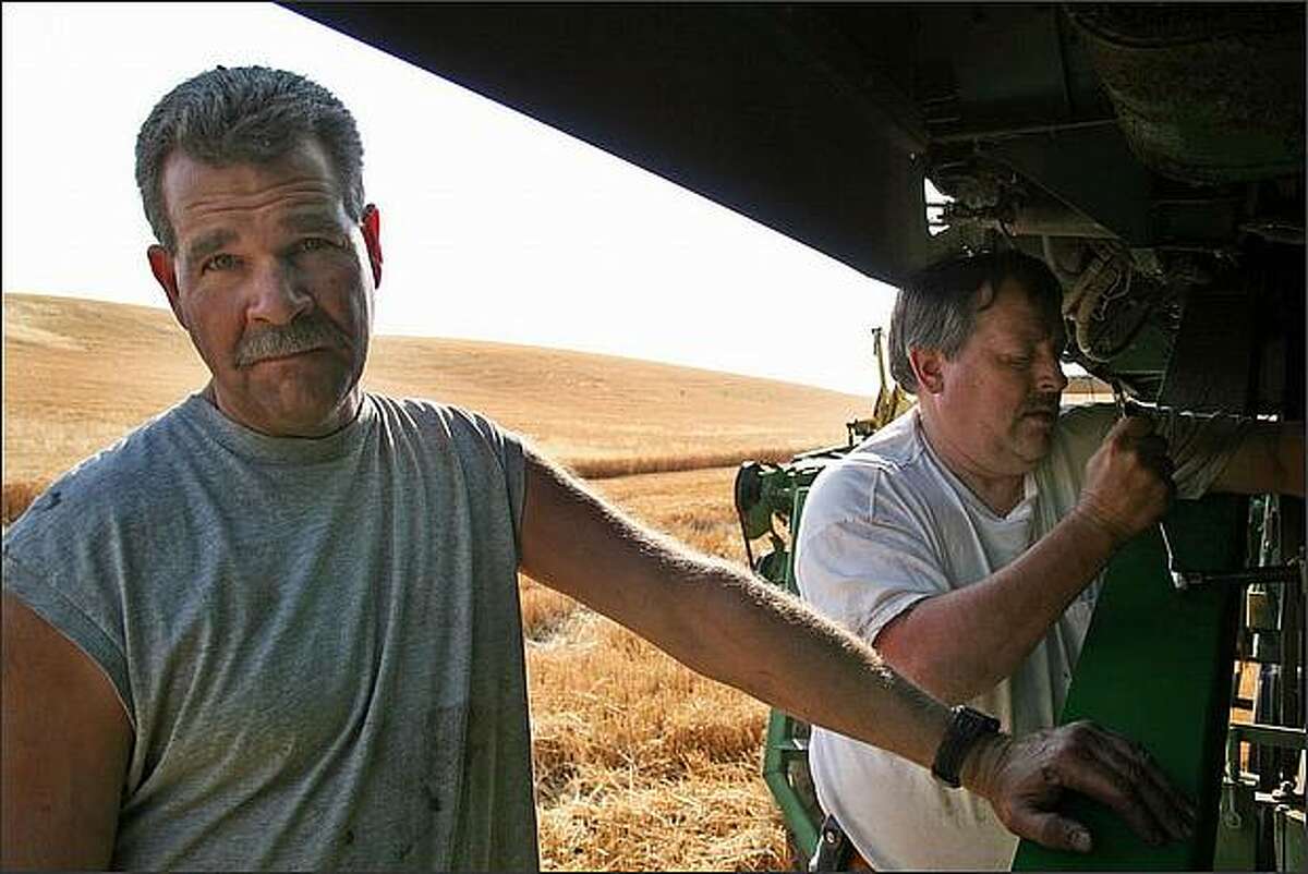 Phil Herman and Bob Holman of Colfax, Wash., work to repair a broken combine during the first days of harvest. As the wheat harvest often lasts only a few weeks, it is important that machines are well maintained.