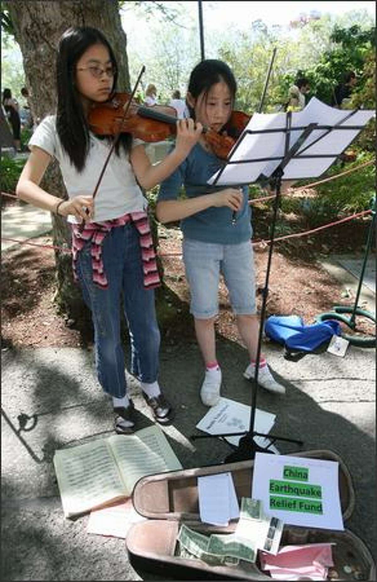 Sophie Ding, 11, left, and Elizabeth West, 12, both of Seattle, played violin to raise money for the Red Cross China Earthquake Relief Fund.