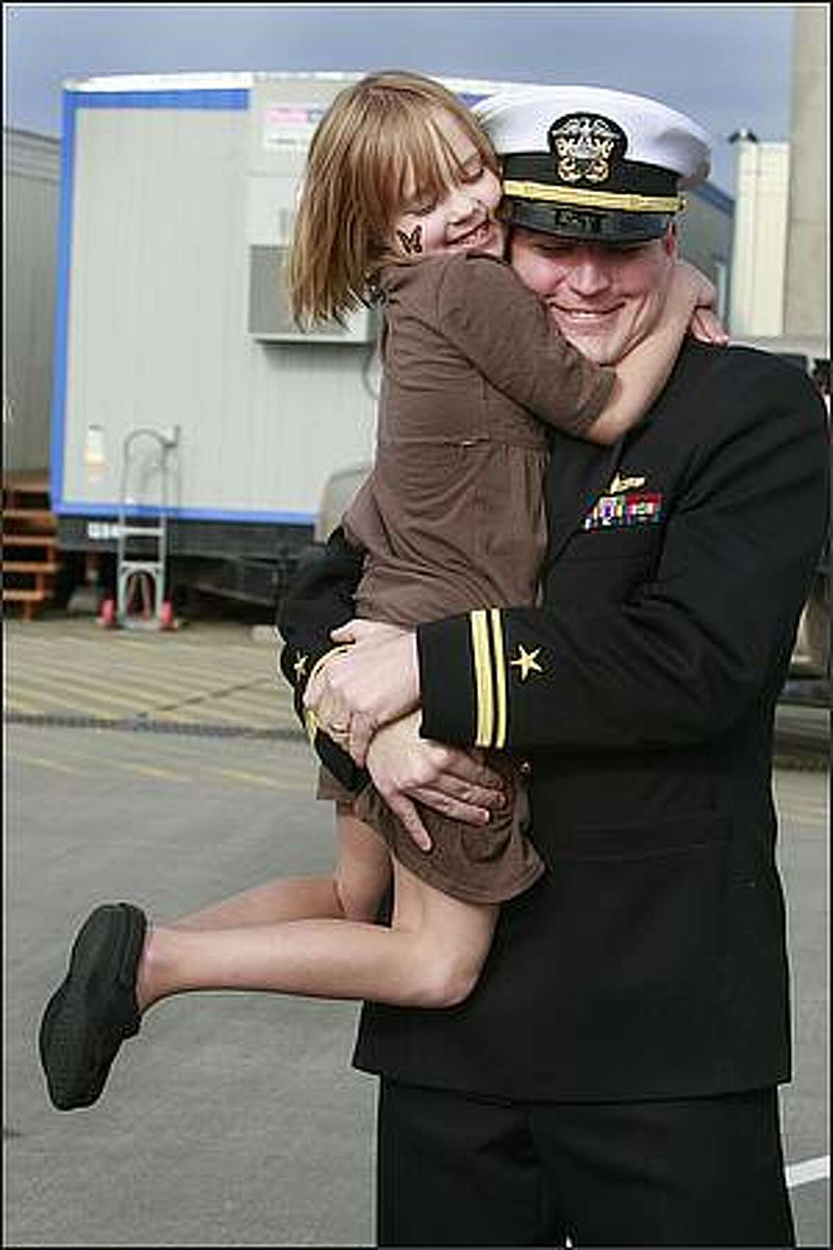 Colleen Huchton, 6, hugs her dad, LTjg Scott Huchton as he arrives home after a seven month deployment on the USS Abraham Lincoln.