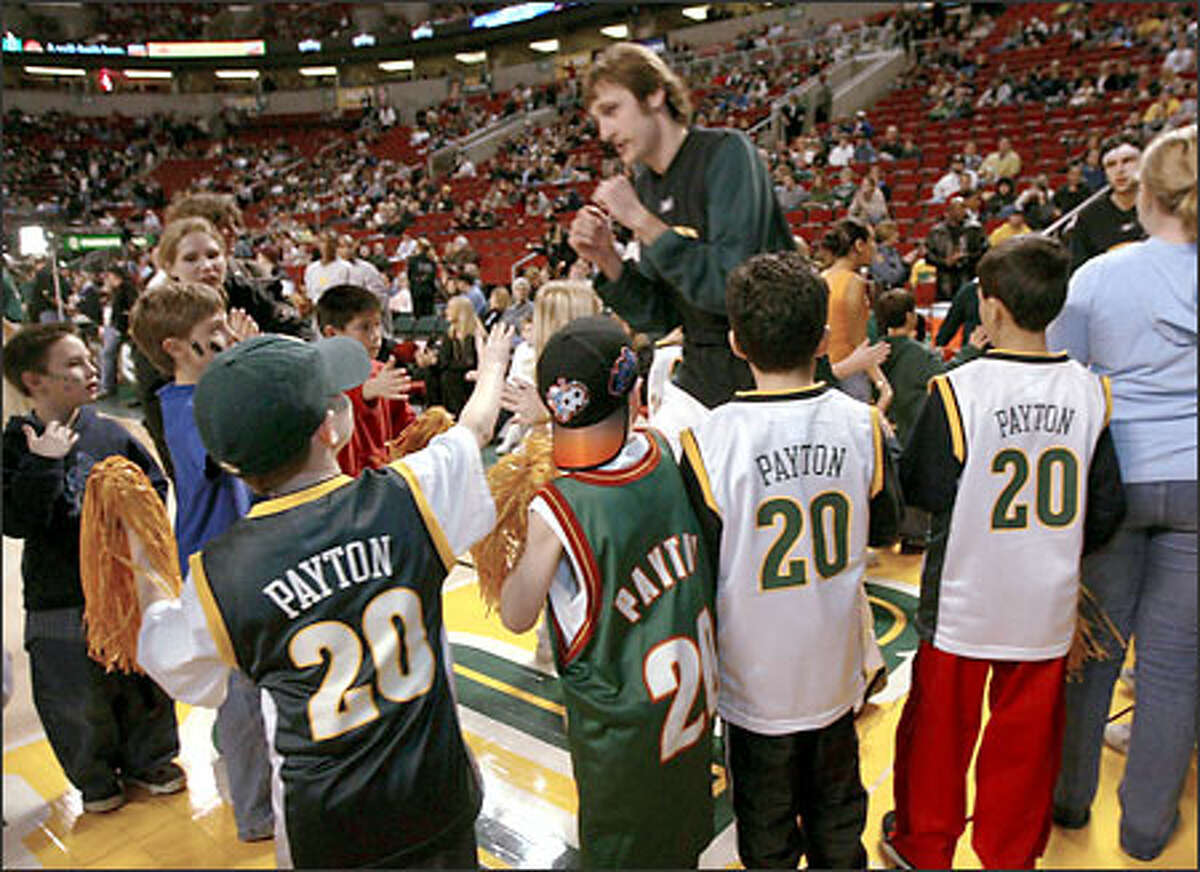 Brent Barry runs a gauntlet of young fans sporting Gary Payton jerseys prior to the Sonics' game with the Bucks, Payton's new team.
