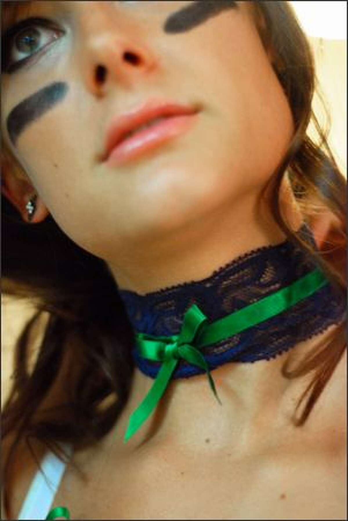 Jenna Bloczynski puts her lace choker on before the Mist photo shoot. These chokers are part of the team's uniform.